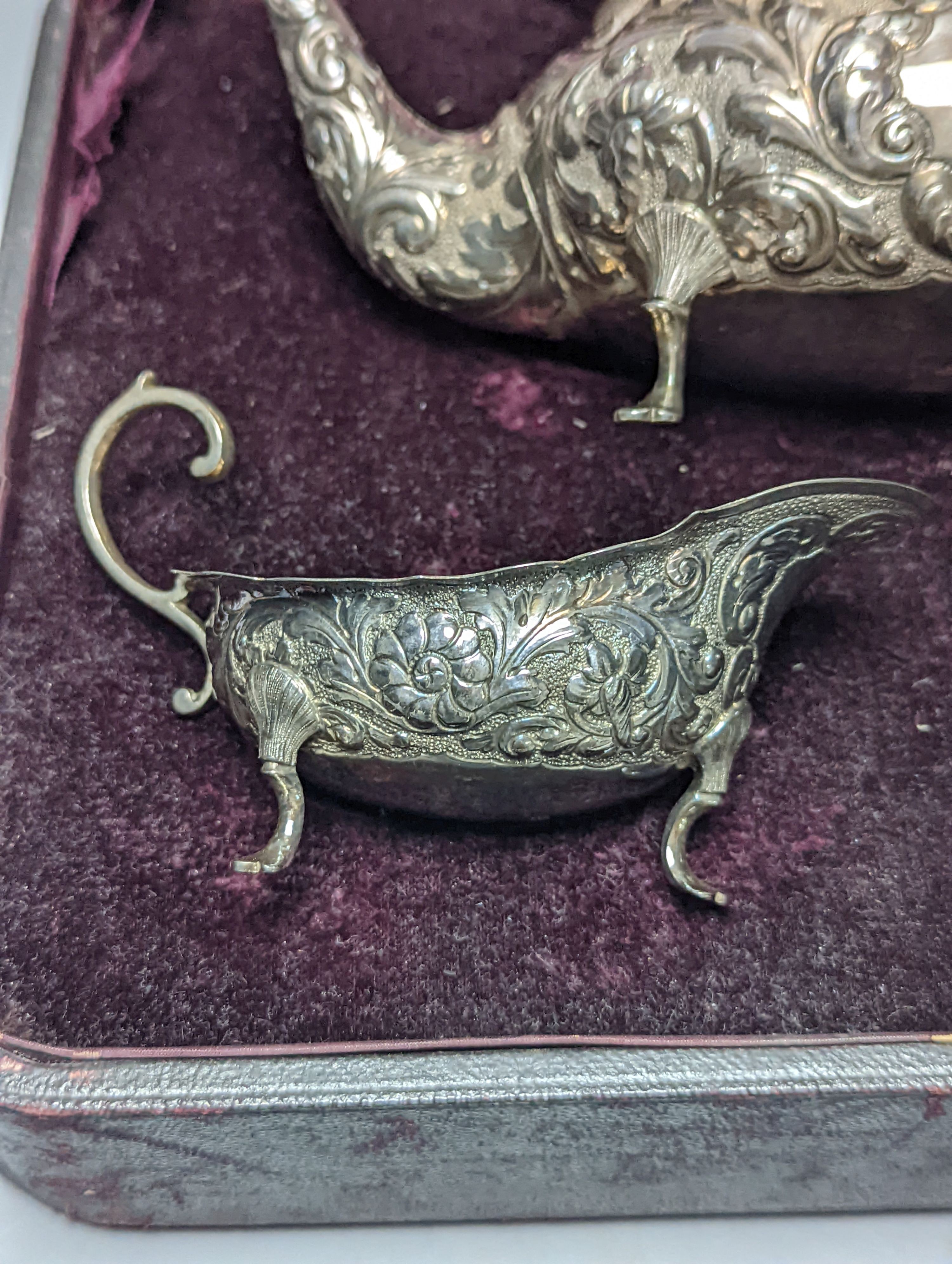 A cased late Victorian Scottish repousse silver three piece tea set, Hamilton & Inches, Edinburgh, 1897, gross 21.5oz.